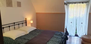 Chambre double confortable dans le Gîte Maligorn, offrant un couchage de qualité pour un séjour en groupe.