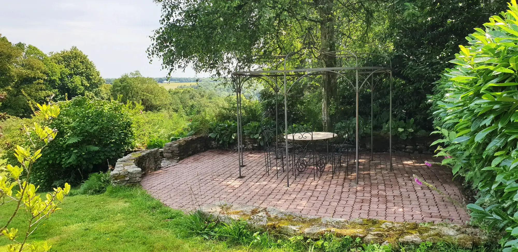 Coin détente ombragé dans le jardin du domaine