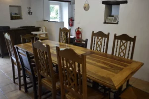 Grande table à manger pour 10 convives dans le Gîte Maligorn, parfaite pour des repas de groupe.